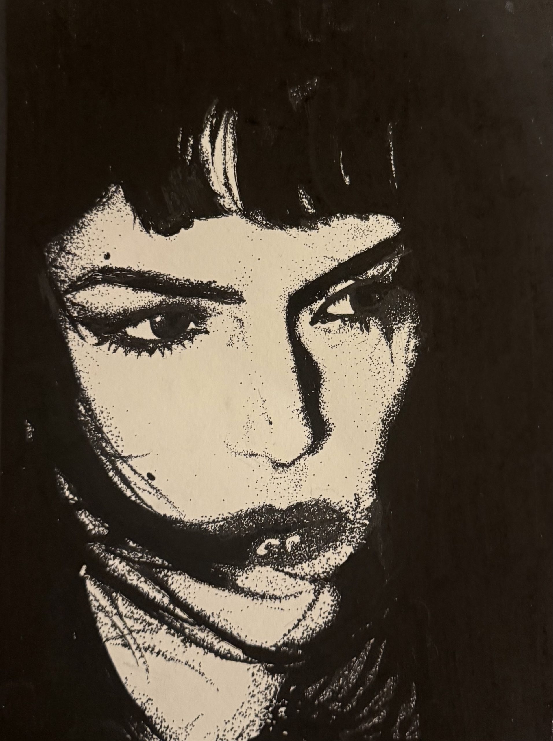 Stippled ink portrait of a woman with a fringe, half in shadow, on a black background